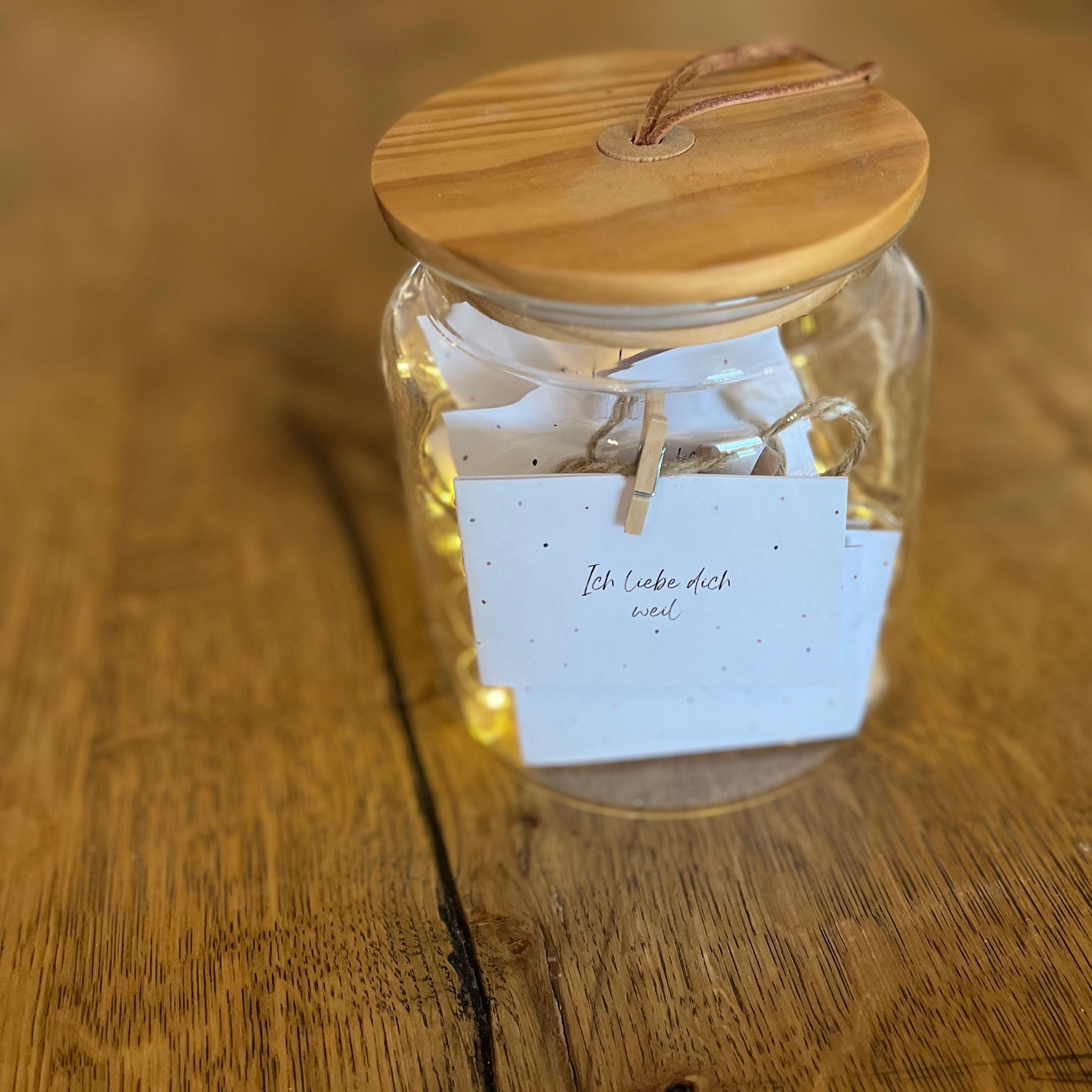 „Ich liebe dich, weil …“-Kärtchen mit Tupfermotiv aufgehängt mit Schnur und Holzklammern.