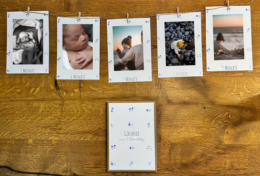 Fotogirlande zum 1. Geburtstag mit blauen Babymotiven, Klammern, Juteschnur und Box für Erinnerungsfotos aus dem ersten Lebensjahr.