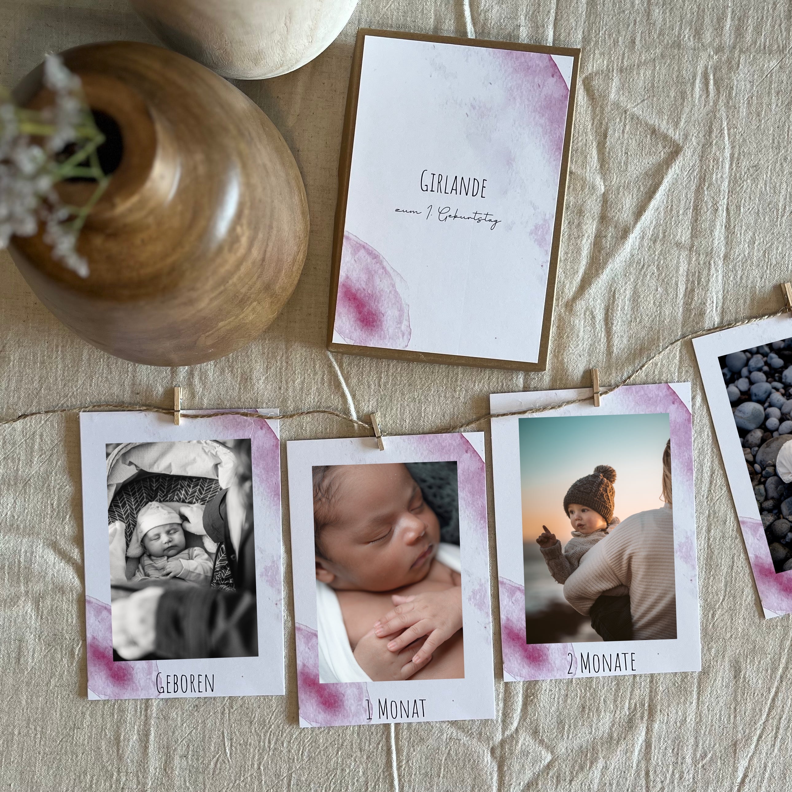 Fotogirlande in Rosa als Dekoration zum 1. Geburtstag mit aufgehängten Fotos.