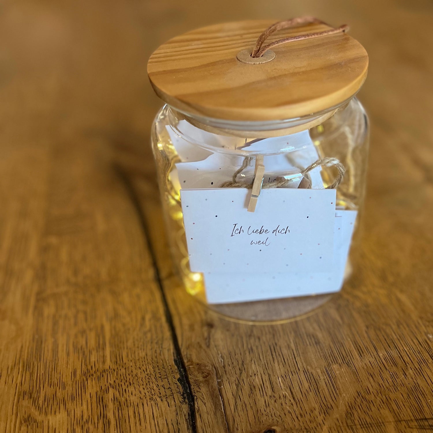 „Ich liebe dich, weil …“-Kärtchen mit Tupfermotiv aufgehängt mit Schnur und Holzklammern.