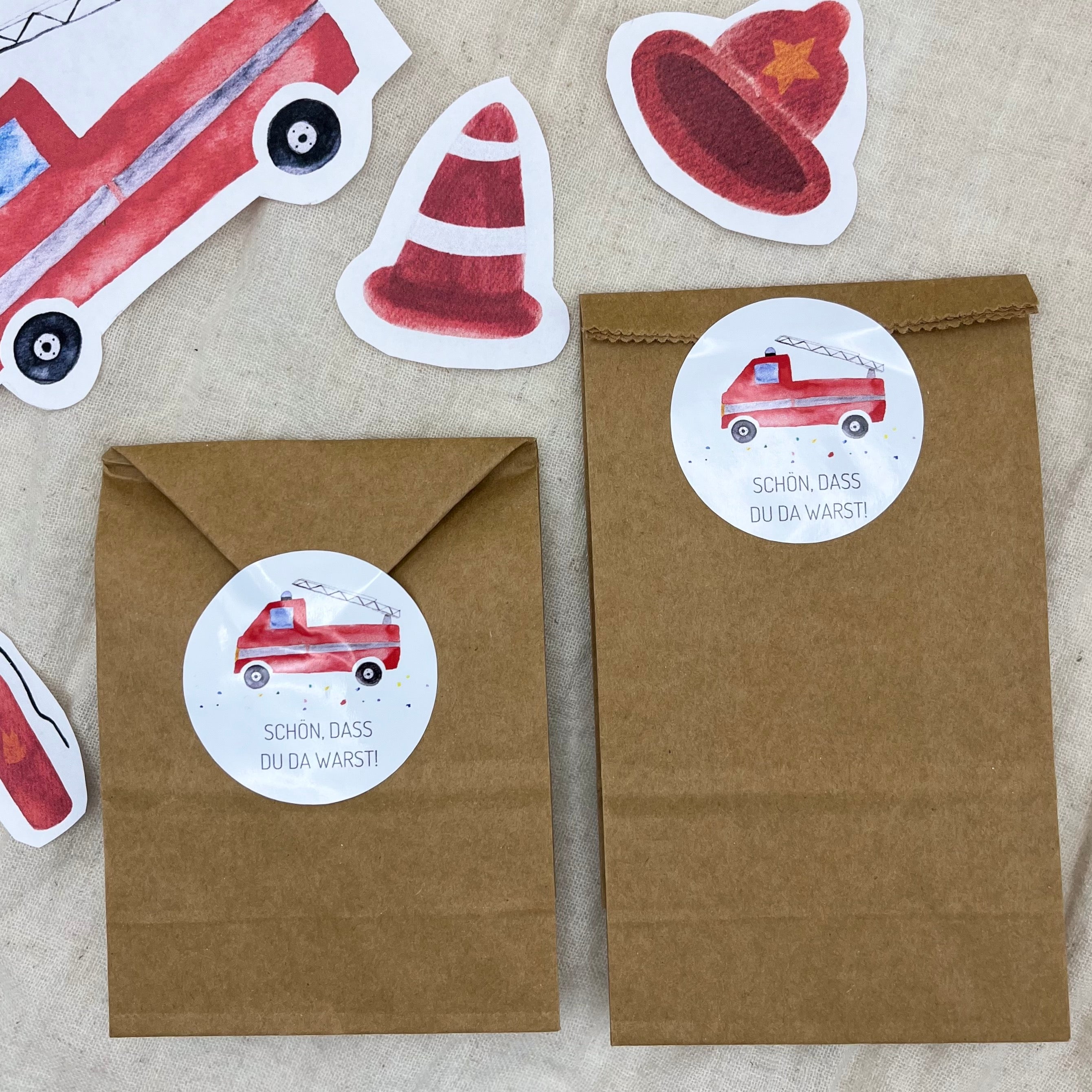 Runde Feuerwehr-Sticker „Schön, dass du da warst“ auf einer Gastgeschenktüte zum Kindergeburtstag.